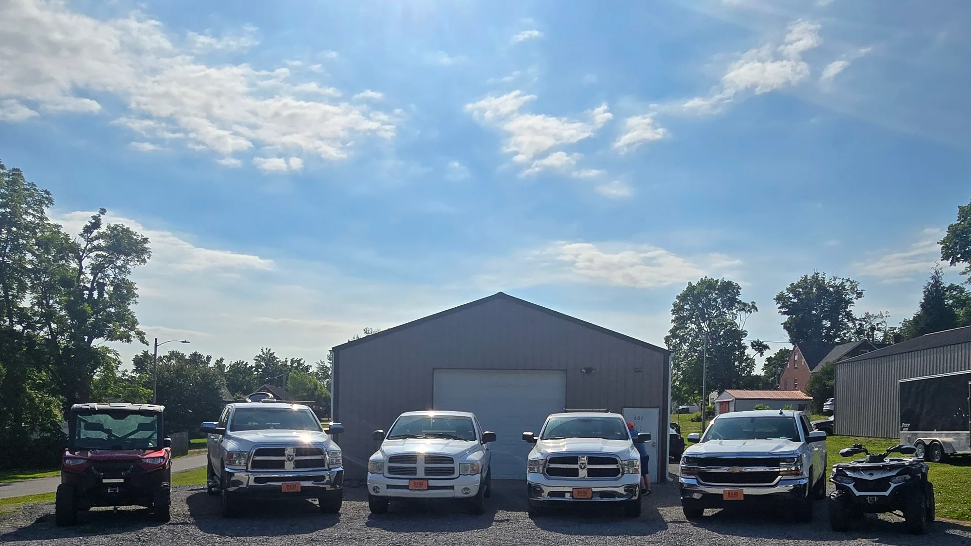 The Doss Land Surveying office in Lafayette, Tennessee, with the firm's field trucks lined up on the gravel lot on a clear morning.
